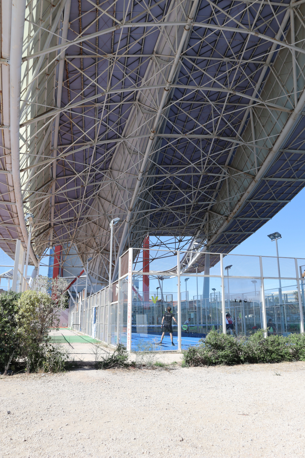 Tennis court under a bridge.